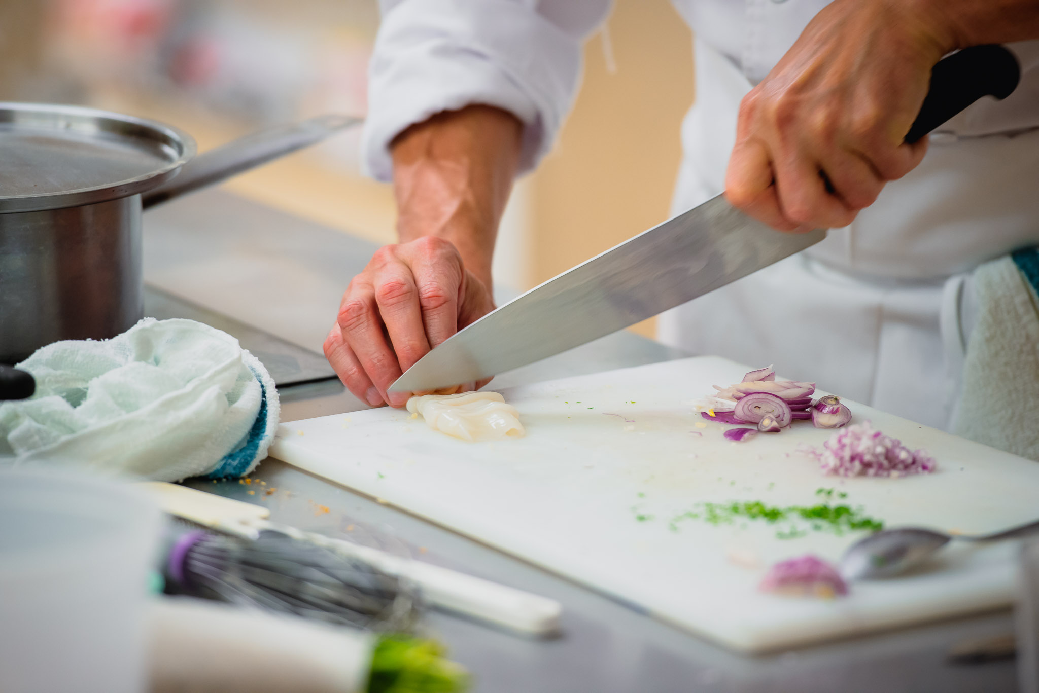Hands slicing an onion — the founding gesture of Culinary Medicine